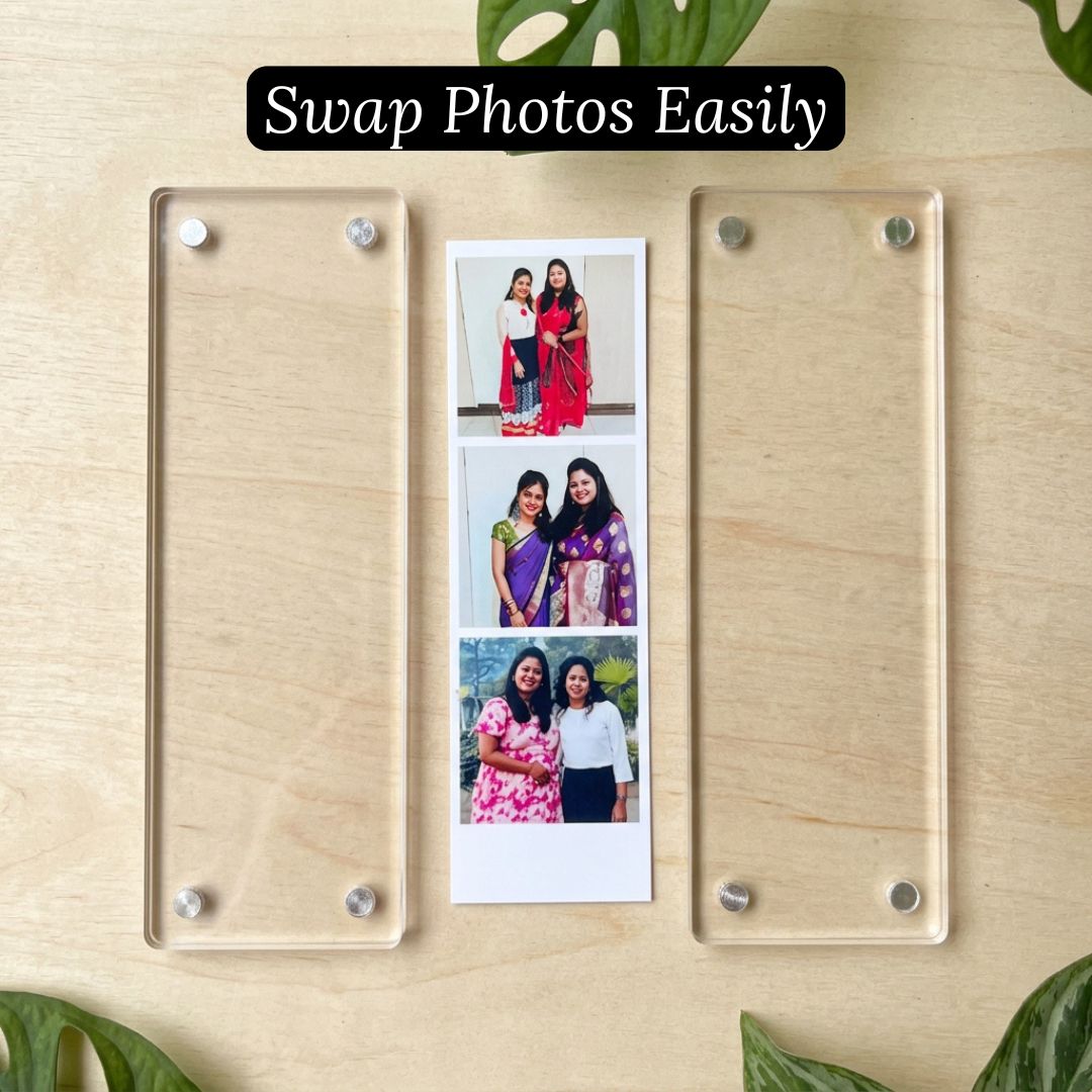 Acrylic photo magnet strip kept open on a wooden surface with a photo paper sheet displaying photos of people.