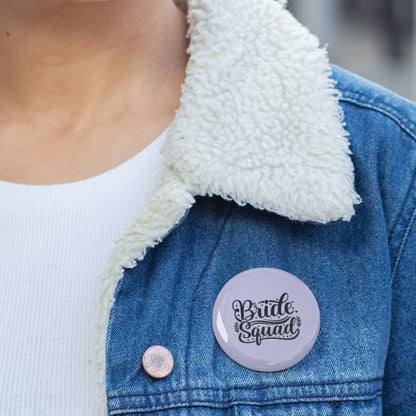 Person wearing a denim jacket with a 'Bridge Squad' pin badge on the chest.