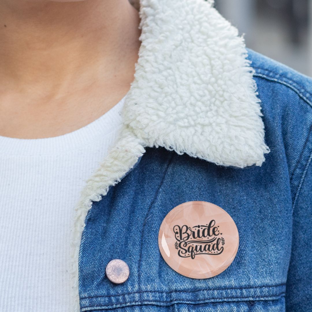 Person wearing a denim jacket with a 'Bride Squad' pin badge