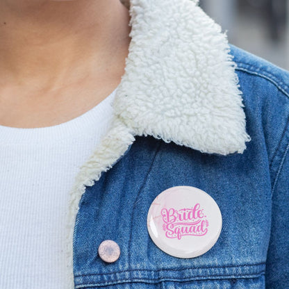 Person wearing a denim jacket with a 'Bride Squad' pin badge on a blurred background
