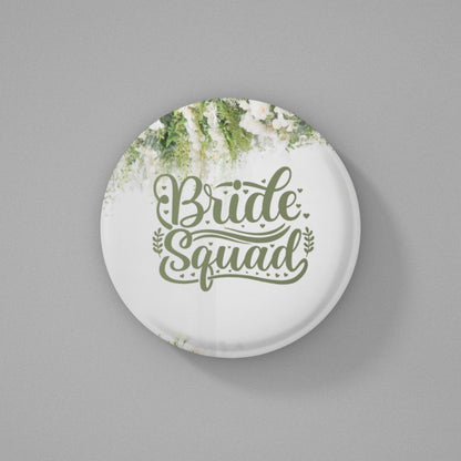 Round white pin badge with 'Bride Squad' text and floral design on a gray background