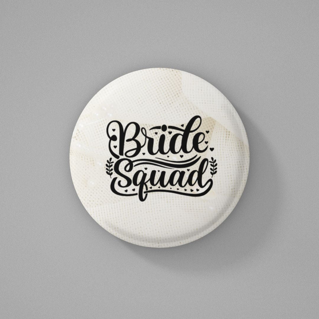 Round shaped pin badge with 'Bride Squad' text written on it and placed on a gray background