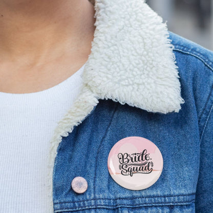 Person wearing a denim jacket with a 'Bride Squad' pin badge on a pink background